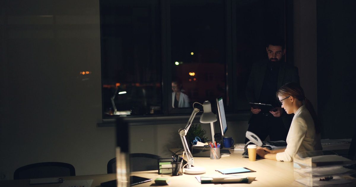 Two people working late in a dimly lit office
