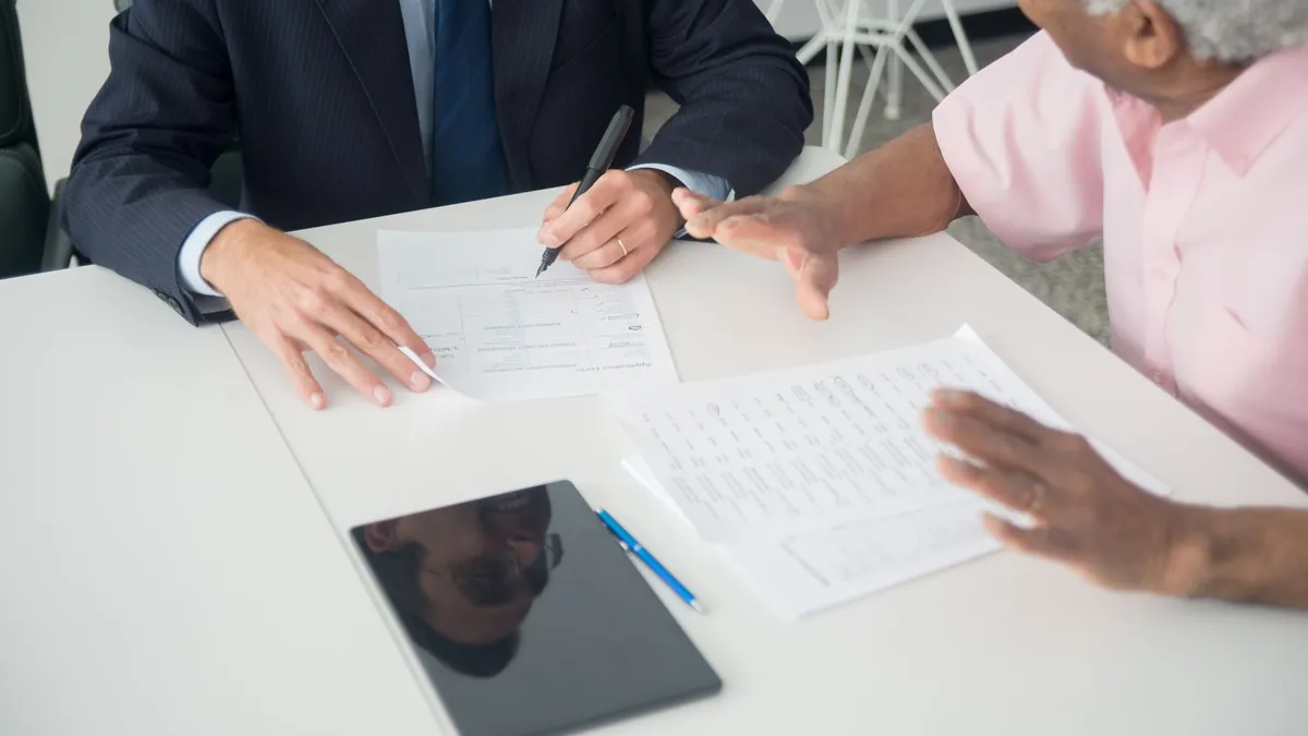 A consultant and a client going through documents together at a table