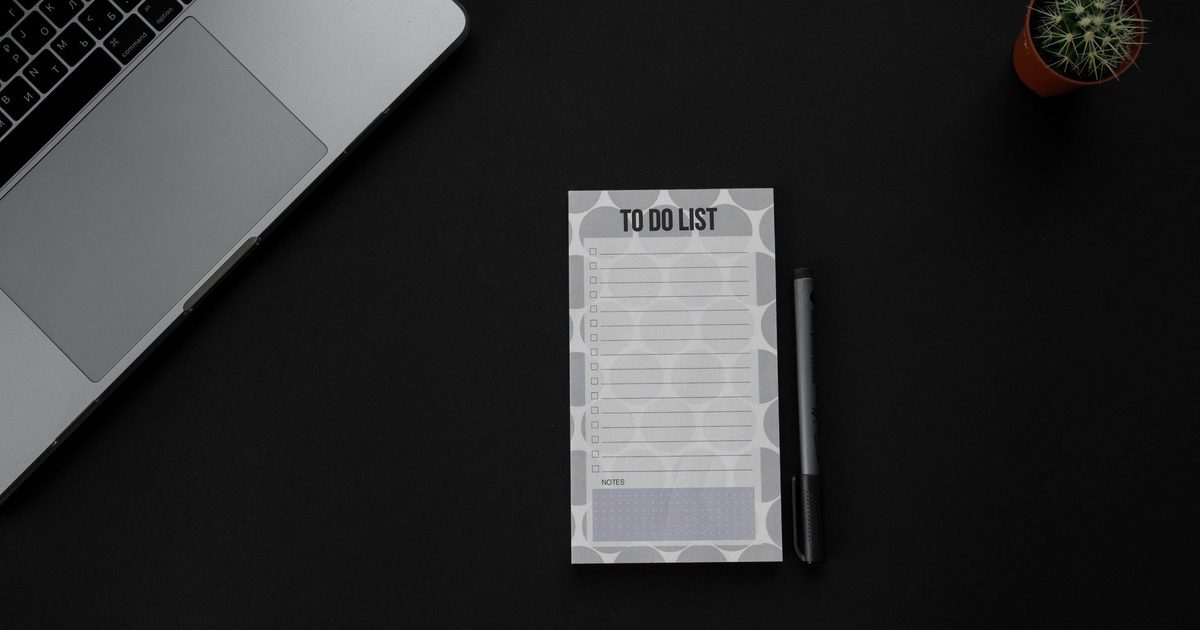 A desk with a laptop and a printed to-do list