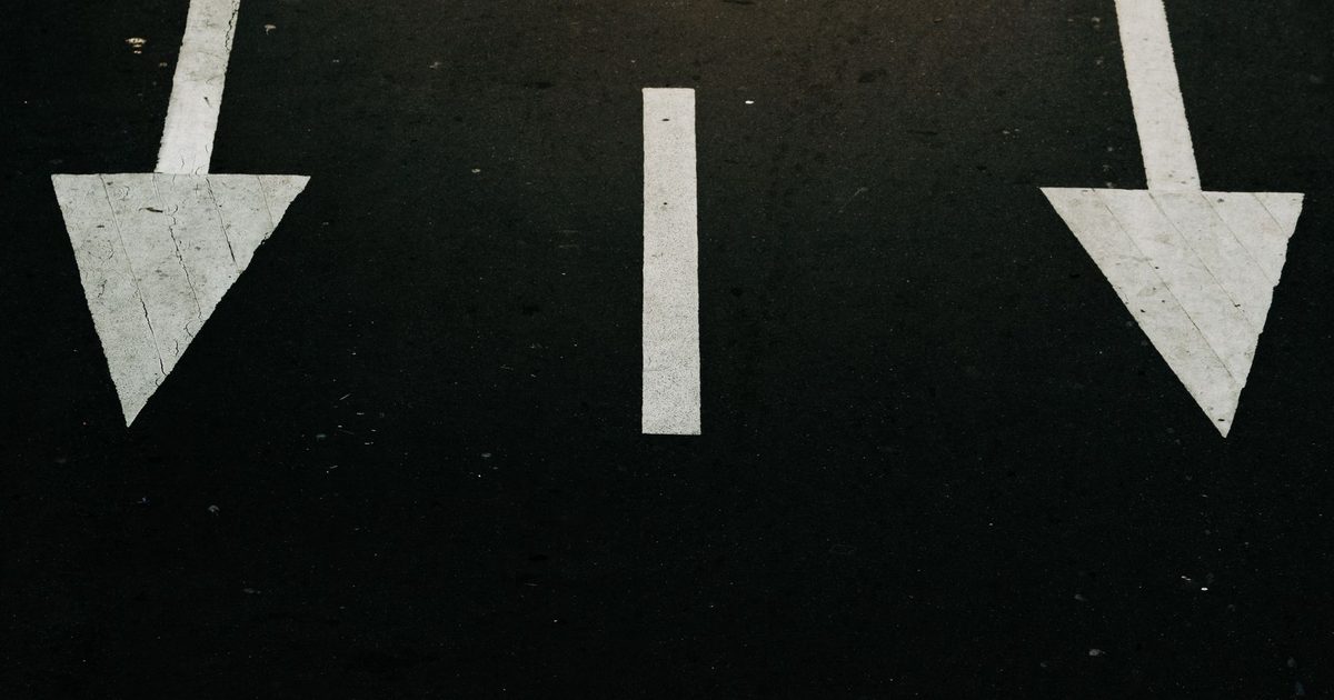 Direction arrows painted on a road surface, pointing three different ways